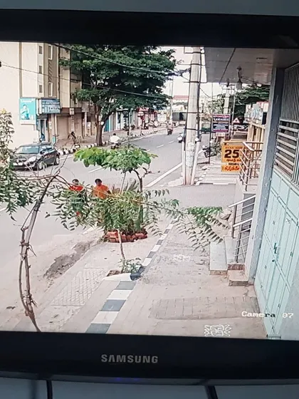 A street view from a Hikvision camera installation, monitoring the sidewalk and road.