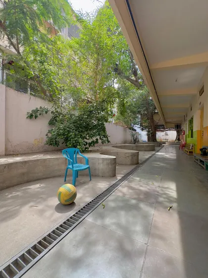 A quiet moment in the school corridor, where simple concrete forms create informal seating and play spaces for the children.