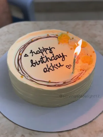 A simple and sweet personalized birthday cake, perfect for a small celebration. The lit candle shows it's ready for a wish.