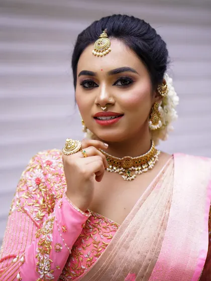 A classic three-quarter portrait. This angle shows the details of the makeup, jewellery, and the elegant fall of the saree.