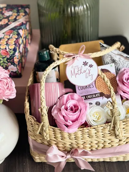 This "Basket of Love" for Mother's Day contains masala tea, makhana, a coffee mug, a Body Shop shower gel, and waffle chip cookies, all beautifully arranged in a wicker basket.