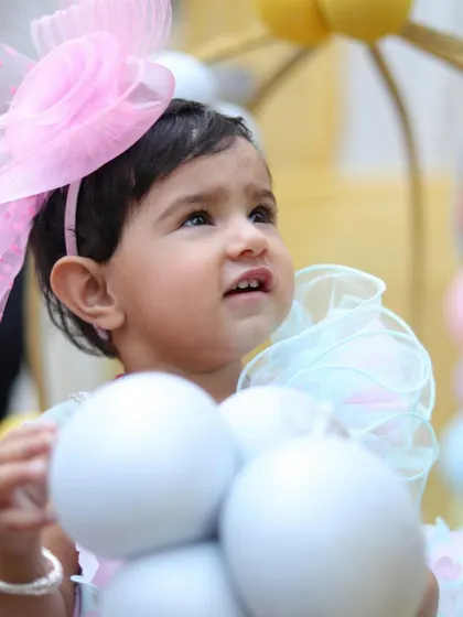 A sweet, expressive portrait of the toddler looking up during her birthday party. My approach to baby photography is to be patient and capture their natural expressions as they explore the celebration.