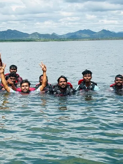 A group of participants and their instructor pose for a photo in the water, celebrating a great day of learning and fun.