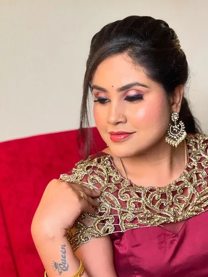 A glamorous party look for Sowmya. This features a bold smokey eye, a contoured base, and a stylish half-updo, perfect for an evening event.