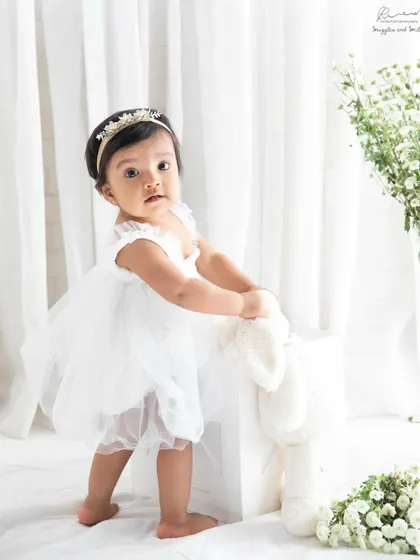 A little princess in her white tulle dress, celebrating her first birthday. This classic, clean studio setup is timeless and beautiful.