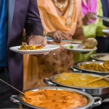 A candid moment of guests serving themselves from our extensive buffet. Our goal is to create a welcoming atmosphere where food becomes a central part of the celebration.