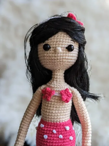 A portrait of the mermaid doll, focusing on her sweet face and long hair.