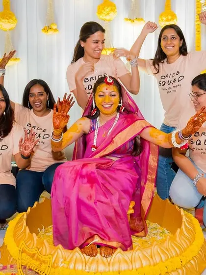 The bride and her "Bride Squad" pose for a fun photo, showing off their turmeric-stained hands.