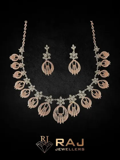This intricate rose gold necklace set features beautifully detailed floral and oval motifs. The craftsmanship gives it a light, airy feel while providing significant sparkle and coverage.