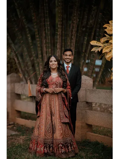 A classic reception portrait of the couple, with the lush greenery of a bamboo grove in the background.