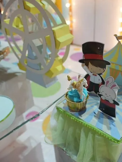Miniature carnival props, including a magician, a rabbit, and a Ferris wheel, used as table centerpieces. These details bring the circus theme to life on a smaller scale.