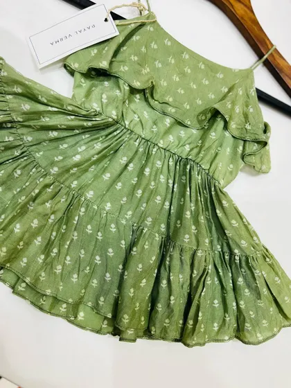 A beautiful tiered summer dress made from 100% cotton. This olive green dress features a delicate white floral block print, spaghetti straps, and ruffles for a playful, breezy look.