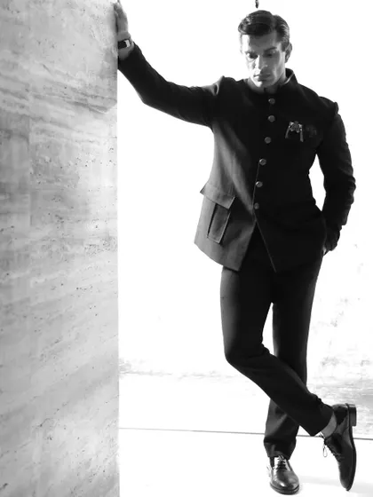 A full-length monochrome shot of Karan Singh Grover, demonstrating a modern and stylish pose against a clean backdrop.