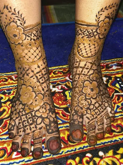 A lovely foot design featuring a net pattern (jaal) accented with bold flowers. The leafy vine around the ankle adds a delicate finishing touch.