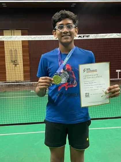 A closer look at Aarav Chettiar with his medals and certificate from the SFA Championship, representing his success in both singles and doubles.