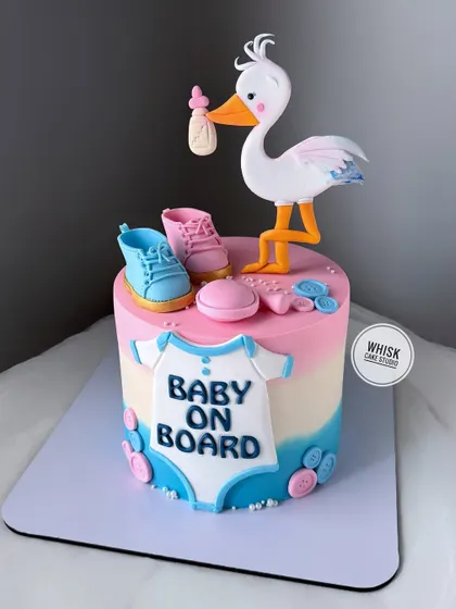A classic "baby on board" stork delivery cake. This gender-neutral design features pink and blue elements, making it perfect for a baby shower.