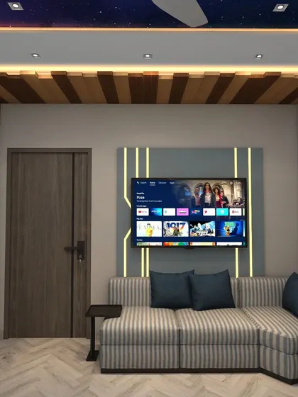 The room also features a cozy TV and lounge area with a striped L-shaped sofa and unique wooden wall paneling.