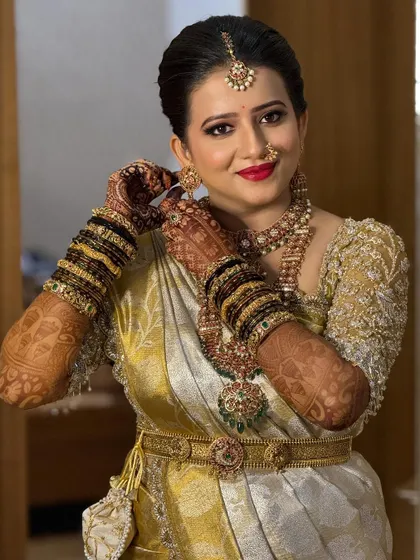 A close-up of this bride's beautiful wedding look. Her gold embroidered blouse and traditional jewelry are a perfect match for her off-white and yellow Kanchivaram saree.