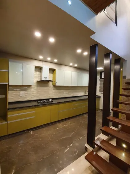 A long parallel kitchen with mustard-yellow base cabinets and white upper cabinets. This design is perfect for long, narrow spaces and adds a cheerful, sunny vibe to the home.