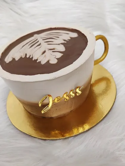 Another coffee-themed cake, this one shaped like a cappuccino cup with latte art on top. A perfect treat for a coffee lover.