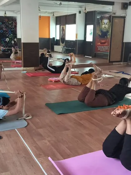 Props are tools for empowerment. Here, my students are using yoga straps in Dhanurasana, the Bow Pose, to get a better lift and a deeper backbend. This technique helps open the shoulders and chest while protecting the lower back.