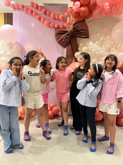 The birthday girl and her friends having a blast and posing for a fun group photo.