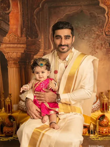A father's love for his little one, captured during a Janmashtami shoot. The baby, dressed as Krishna, looks so content and happy in her dad's arms.