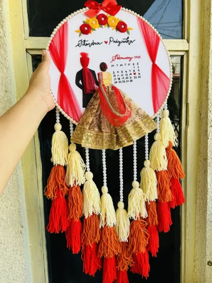 I craft detailed wedding embroidery hoops that capture the essence of your special day. This piece features a custom portrait, names, and a calendar marking the wedding date, all brought to life with 3D fabric elements and colorful tassels.