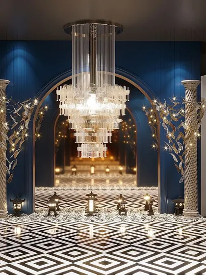 An ambiance of grandeur and luxury. This is a reception area we designed for a light showroom, featuring a dramatic entryway with classical pillars, a massive chandelier, and bold geometric flooring.