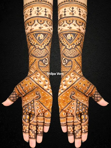 A unique bridal design featuring Warli art figures at the top, blended with traditional peacock and geometric patterns.