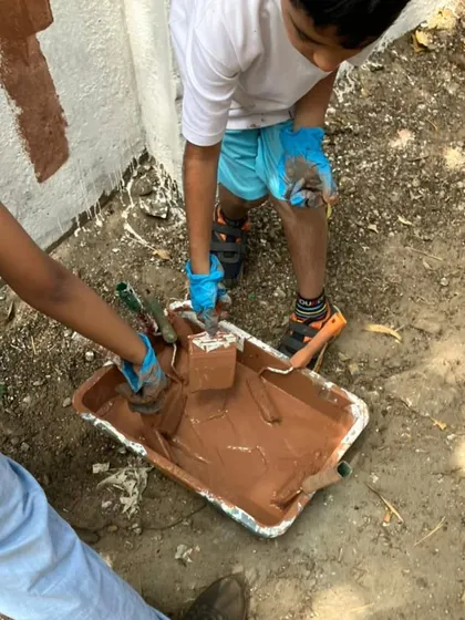 With focus and care, children use rollers and brushes to help paint the facility walls, taking pride in contributing to the welfare of the animals.