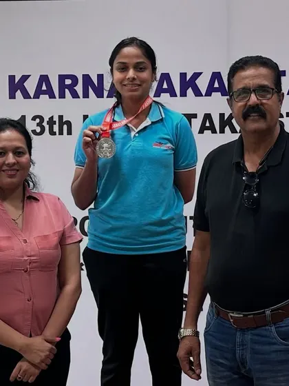 A moment of pride for our shooter and her parents on the podium after winning a medal in the Air Pistol event.