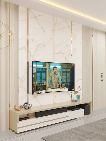 A luxurious TV wall design featuring a mix of fluted and marble-finish panels with inlaid gold-colored strips. The design is both grand and contemporary.