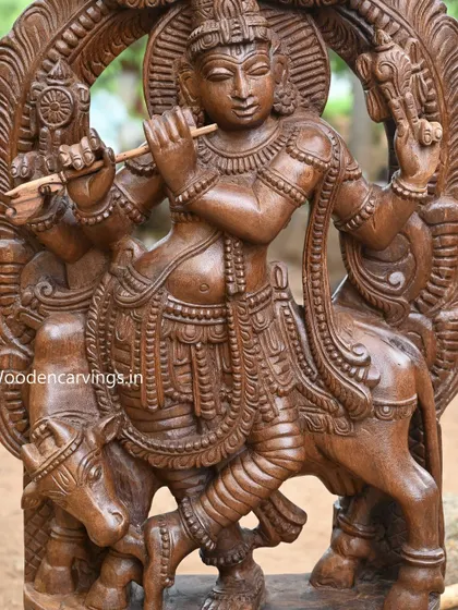 A detailed shot of the four-armed Krishna, focusing on the intricate carvings of his torso and arms.