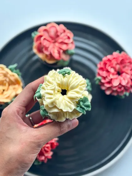 A closer look at my edible floral cupcakes. Each one is a mini work of art, with different flower designs like roses, dahlias, and succulents, all hand-piped with delicious buttercream in a variety of colors.