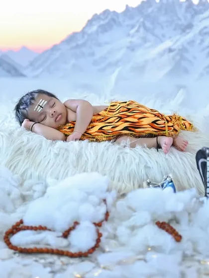 For the festival of Mahashivaratri, I designed this divine 'Bala Shiva' theme. Here, the newborn is sleeping peacefully on a cloud-like bed with a backdrop of the Himalayas, complete with a miniature trishul and damaru.