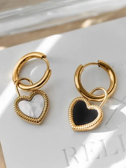 A pair of versatile hoop earrings with removable heart charms. One charm is black and the other is white mother-of-pearl, so you can mix and match.