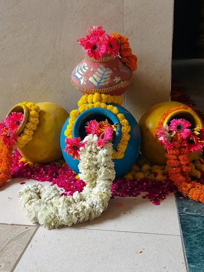 We create beautiful traditional decor pieces like these decorated pots with overflowing marigold and rose garlands, perfect for entrances and walkways.