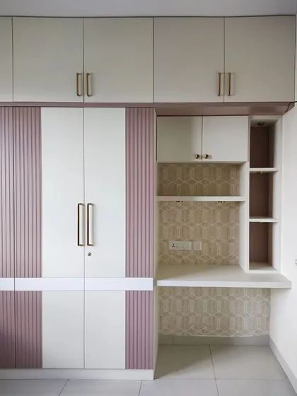 A closer view of the wardrobe and study area, showing the patterned wallpaper and open shelving for display.