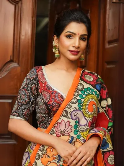 A vibrant Pen Kalamkari saree featuring a lively mix of colors and traditional motifs like peacocks and elephants. Paired with a printed blouse, this look is a celebration of Indian folk art.