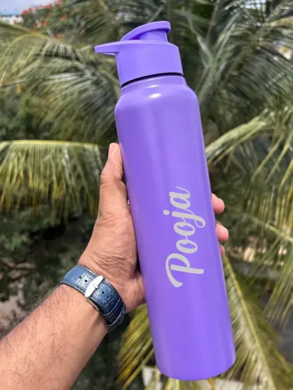 A vibrant purple personalized water bottle with a sipper lid. The name is elegantly engraved down the side.