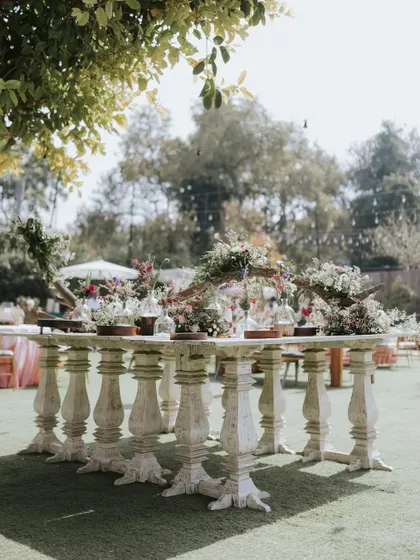 A unique table setup with carved white legs, perfect for a vintage or rustic themed event.