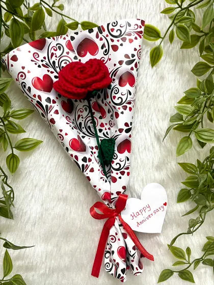 A single red rose wrapped in cute heart-patterned paper, with a little "Happy Anniversary" tag. It’s the small, personal touches that make a gift special.