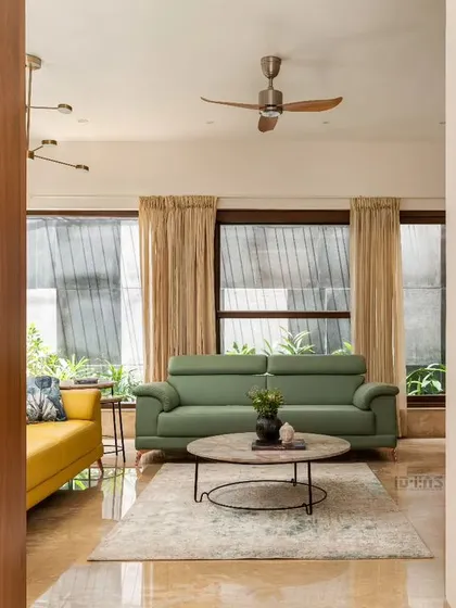 A wooden partition provides a subtle visual separation in this open-plan living room without obstructing light or flow. This view highlights how we layer spaces and textures to create depth and interest.