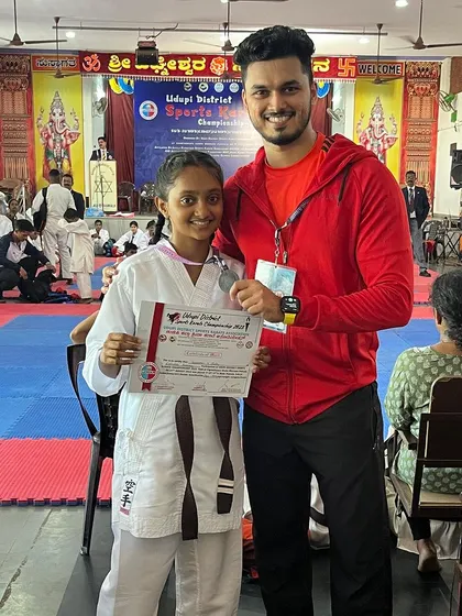 A student proudly shows her silver medal. Every competition is a valuable learning experience.