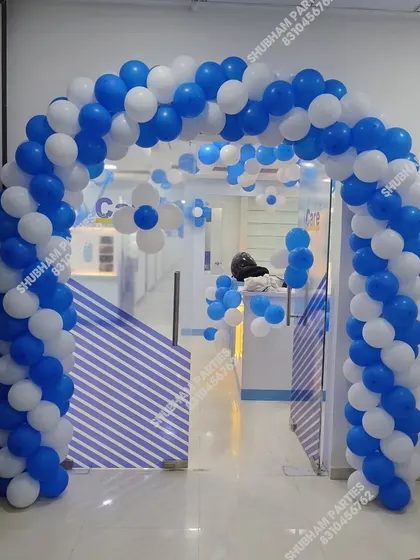 A blue and white balloon arch at the entrance of the clinic, welcoming guests.