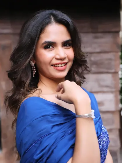 The royal blue outfit is beautifully complemented by a neutral makeup palette and elegant, cascading earrings.