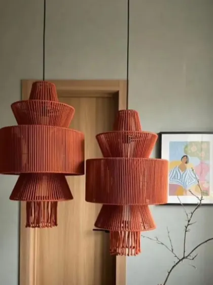 Two of our tiered, terracotta-colored pendant lights hanging side-by-side. The stacked design adds a sculptural element, making them a stylish choice for adding a pop of color and modern design to a space.