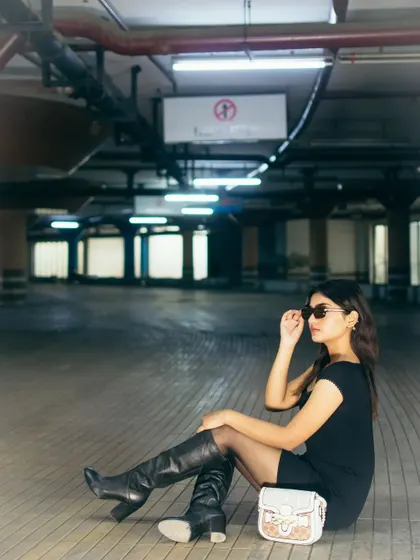 A seated portrait in the same parking garage, using the empty space to create a sense of scale and isolation. This shot has a cinematic, moody quality, perfect for storytelling.