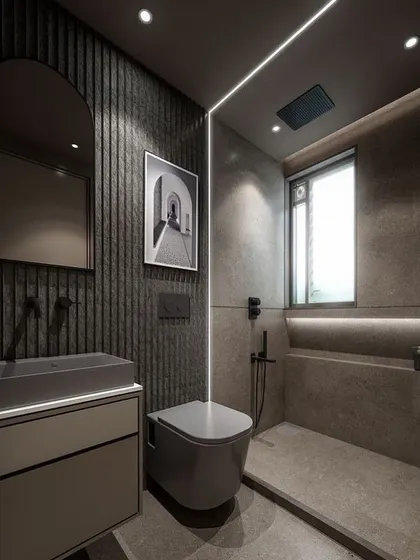 This angle of the grey bathroom shows the built-in shower niche with accent lighting, a practical feature for storing toiletries. The large window allows natural light to enter, balancing the dark and moody color scheme.